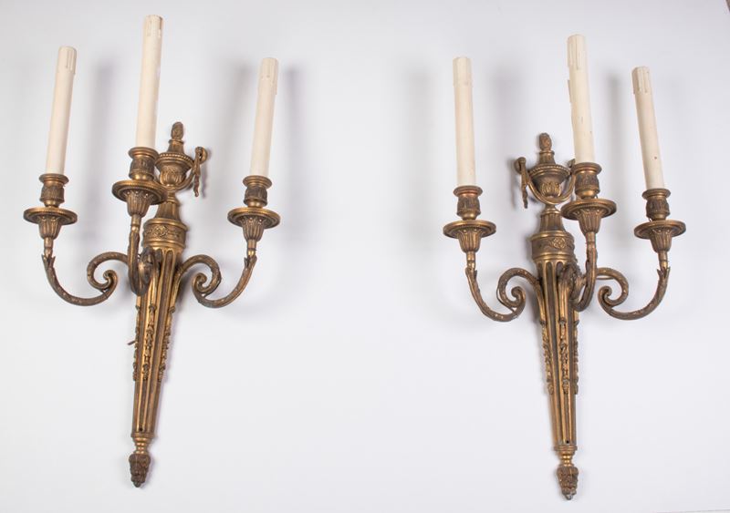 Coppia di appliques a tre luci in bronzo dorato