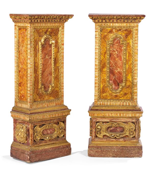 Due basi in legno intagliato, dorato e laccato a finto marmo