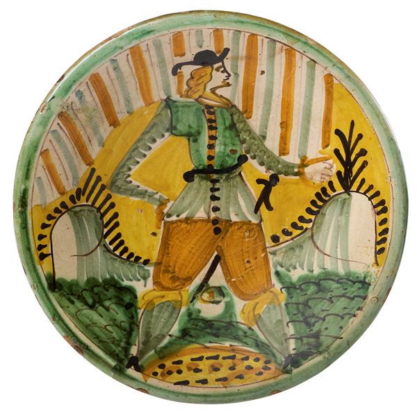 Due piatti in maiolica policroma giallo, azzurro, ocra e manganese