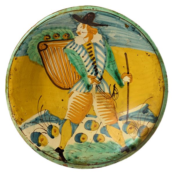 Piatto in maiolica policroma giallo, ocra, verde e blu