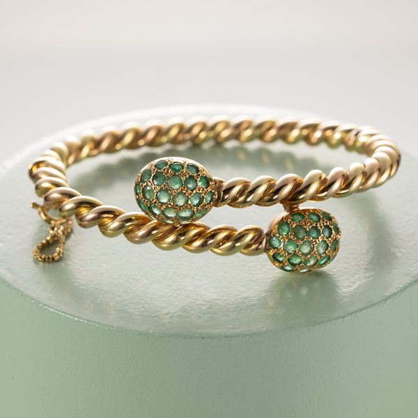 Bracciale contrarié rigido in oro giallo con piccoli smeraldi