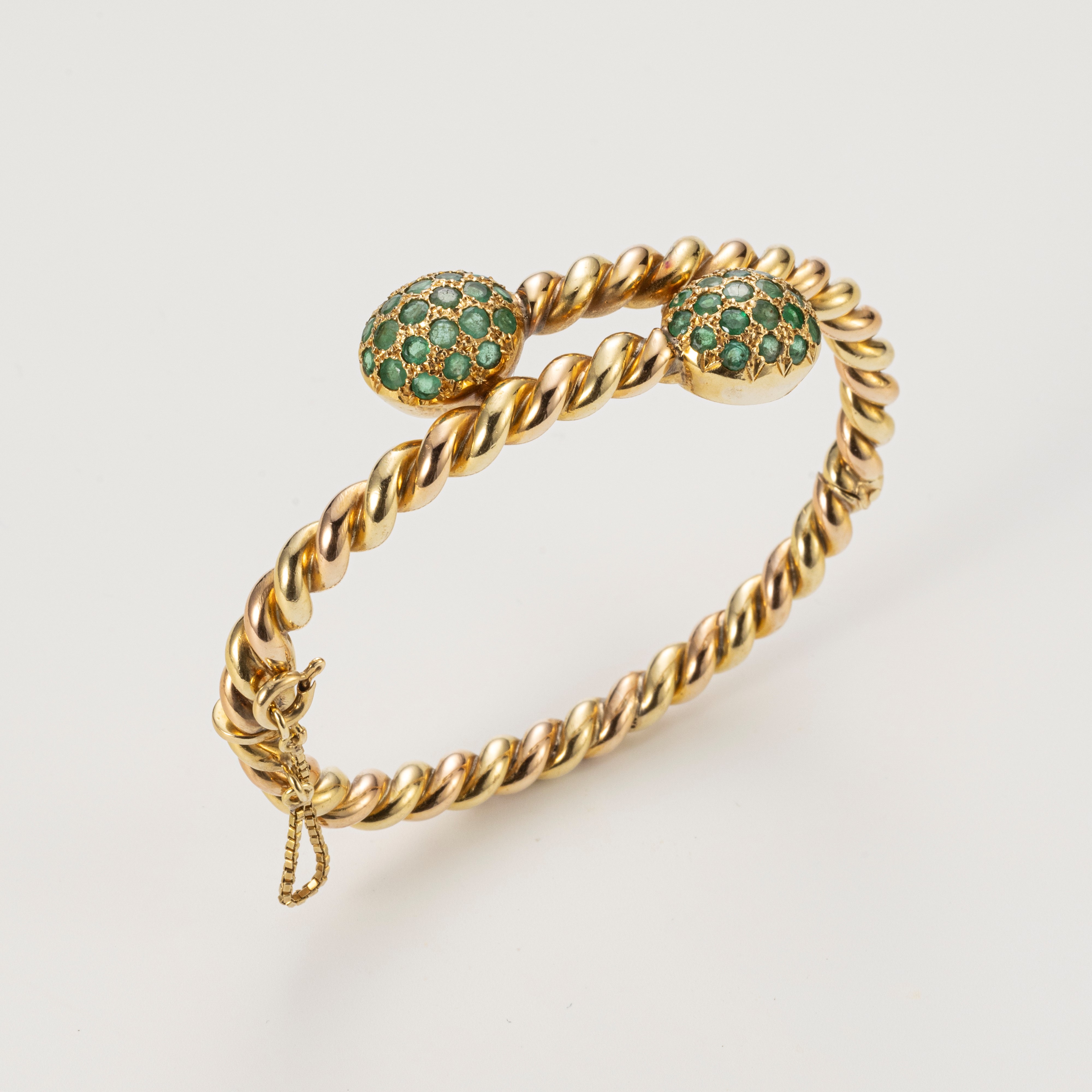 Bracciale contrarié rigido in oro giallo con piccoli smeraldi