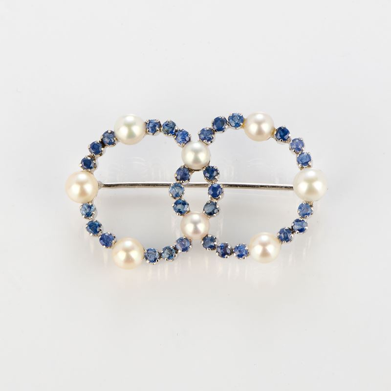 Spilla a due cerchi in oro bianco con zaffiri e perle coltivate