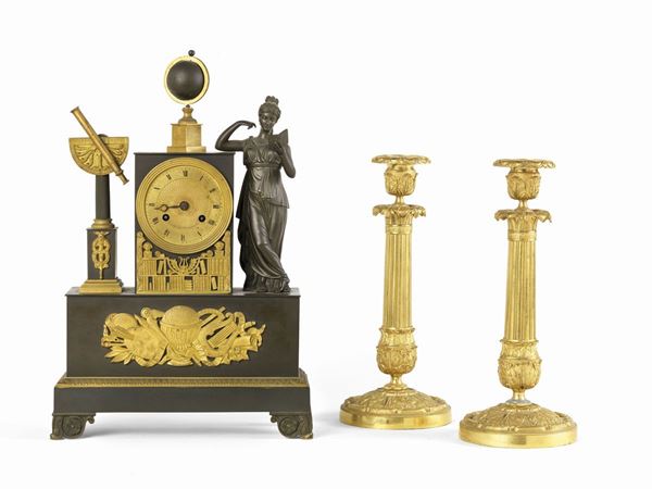 Orologio e due candelieri in bronzo dorato e brunito