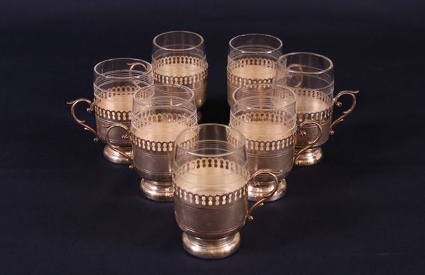 Sette bicchieri in vetro molato con supporto in metallo argentato