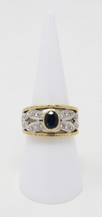 Anello a Fascia Traforata in Oro Giallo e Bianco con Zaffiro Ovale al Centro e Piccoli Brillanti