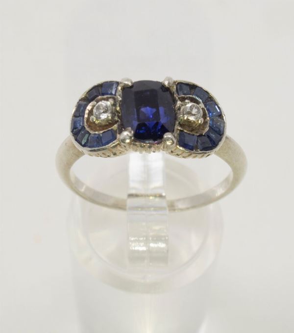 Anello in oro bianco, zaffiro centrale, zaffiri carrè laterali e piccoli brillanti