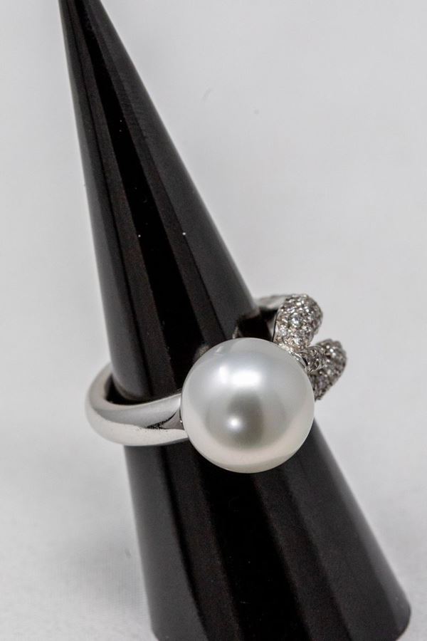 Anello in oro bianco, perla centrale e gambo pavé di brillanti