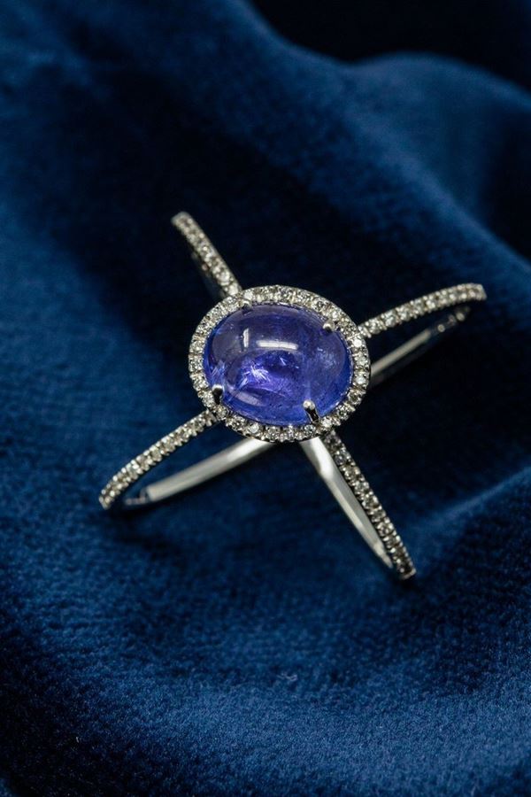 Anello in oro bianco, tanzanite cabochon centrale e corolla pavé di brillanti