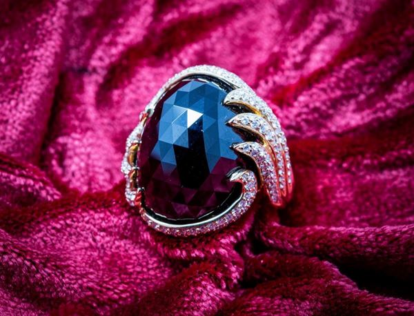 Anello in oro giallo con bordi pavé di brillanti e onice ovale sfaccettata centrale